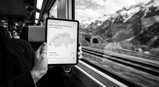 La ventana de un tren enmarca un paisaje montañoso que pasa.