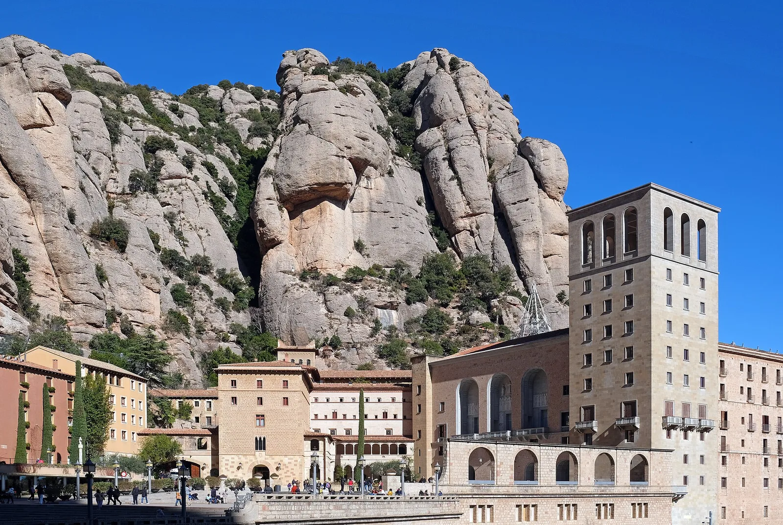 The Santa Maria de Montserrat Abbey buildings below the jagged rock peaks of Montserrat
