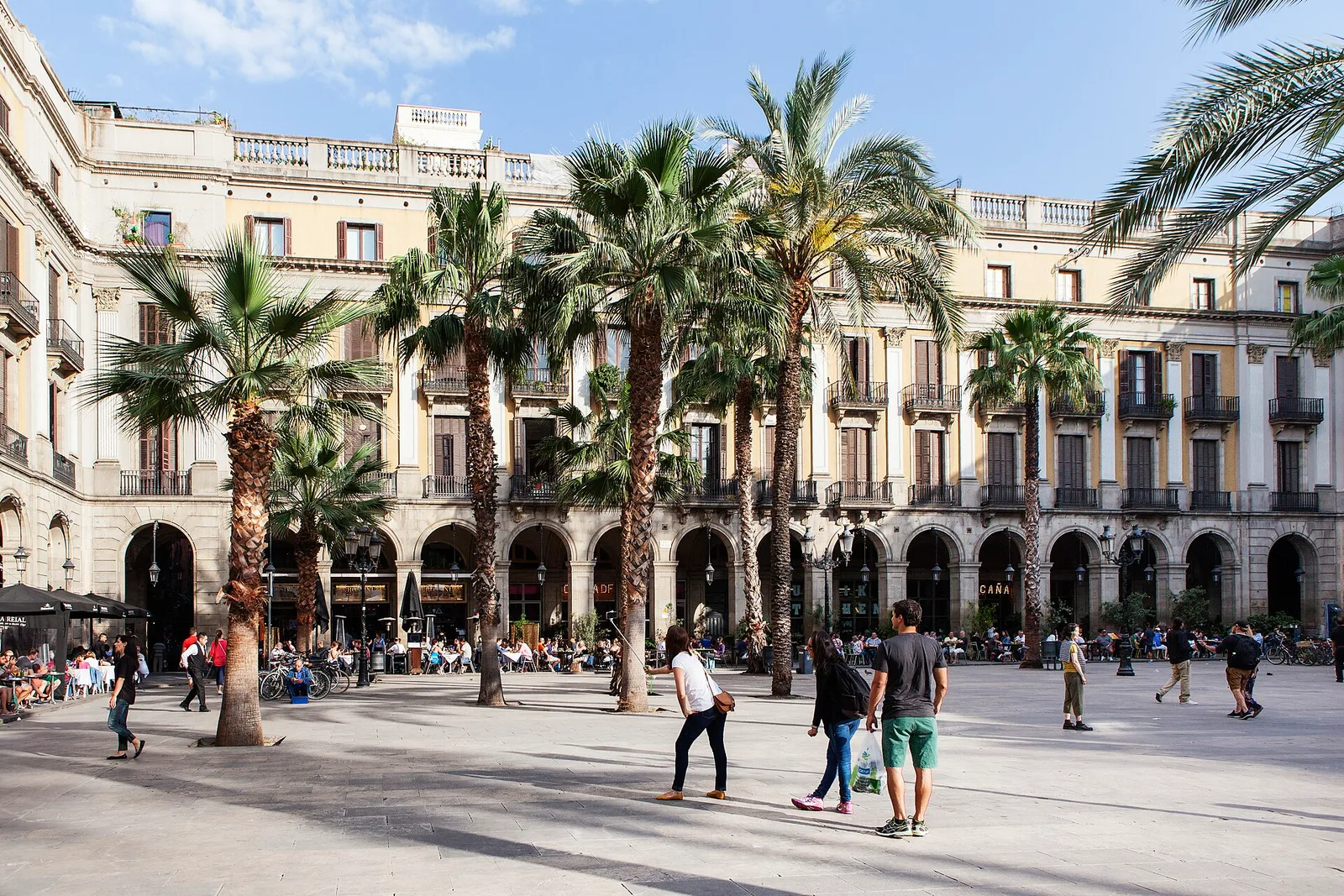 Palm trees and arcaded cream-colored buildings around Plaça Reial
