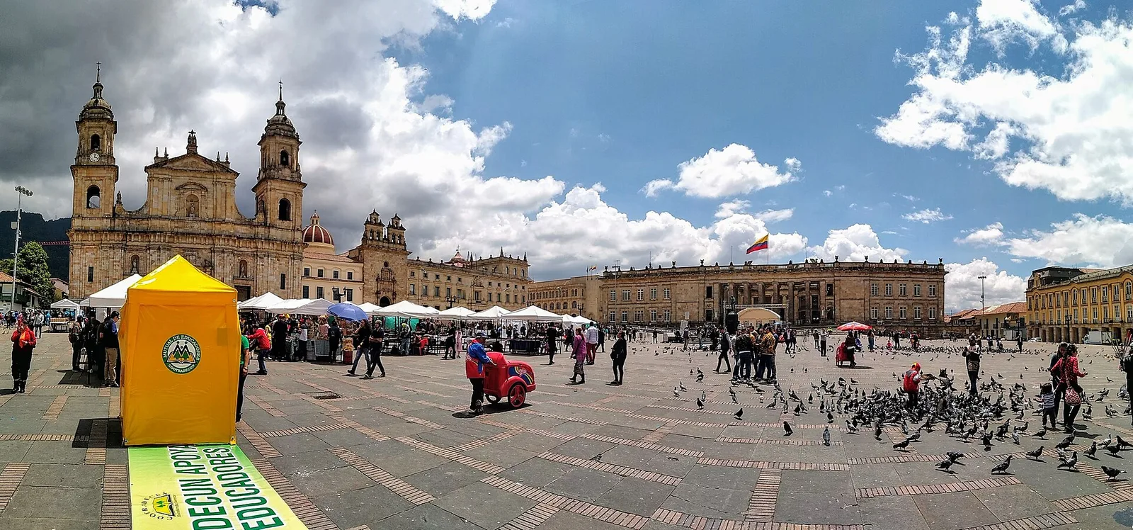 Plaza de Bolívar, a wide cobbled square with pigeons, tents, and the cathedral and government buildings along its far side