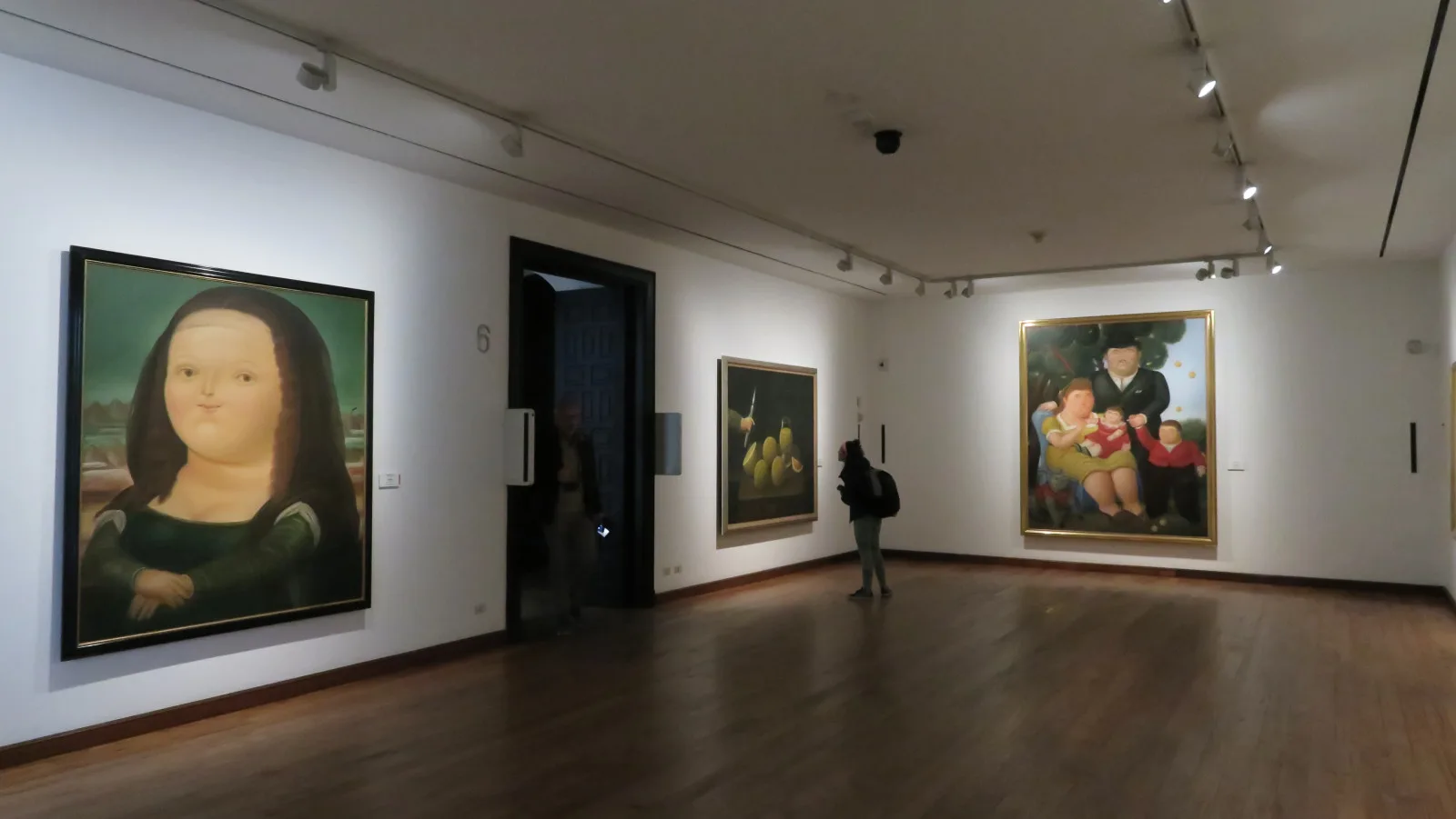 A gallery of the Botero Museum with round-figured paintings by Fernando Botero on white walls