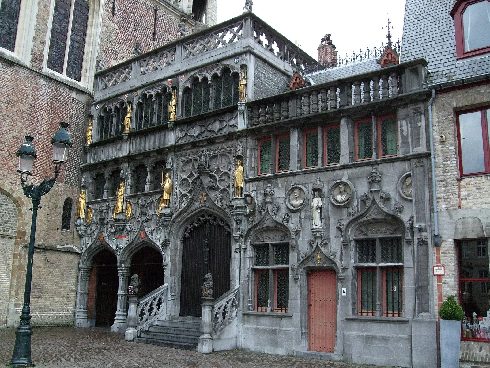 The ornate Gothic facade of the Basilica of the Holy Blood with gilded statues