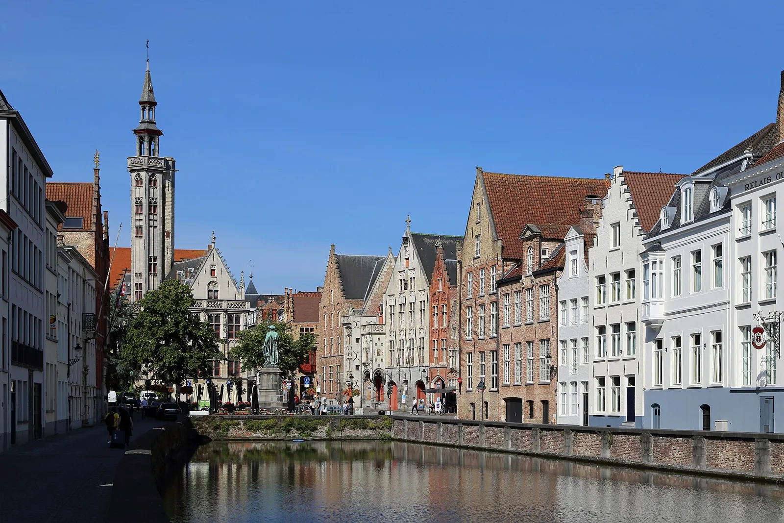 Gabled merchant houses along the Spiegelrei canal, with the Poortersloge tower behind