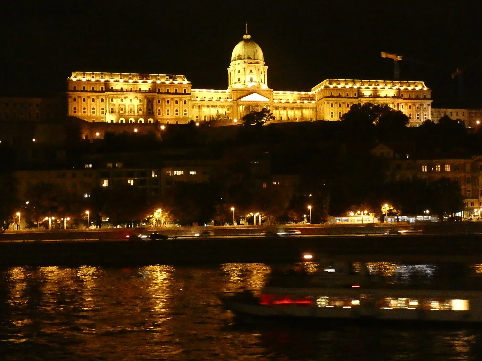 The floodlit Buda Castle palace and its dome on the hill above the Danube at night