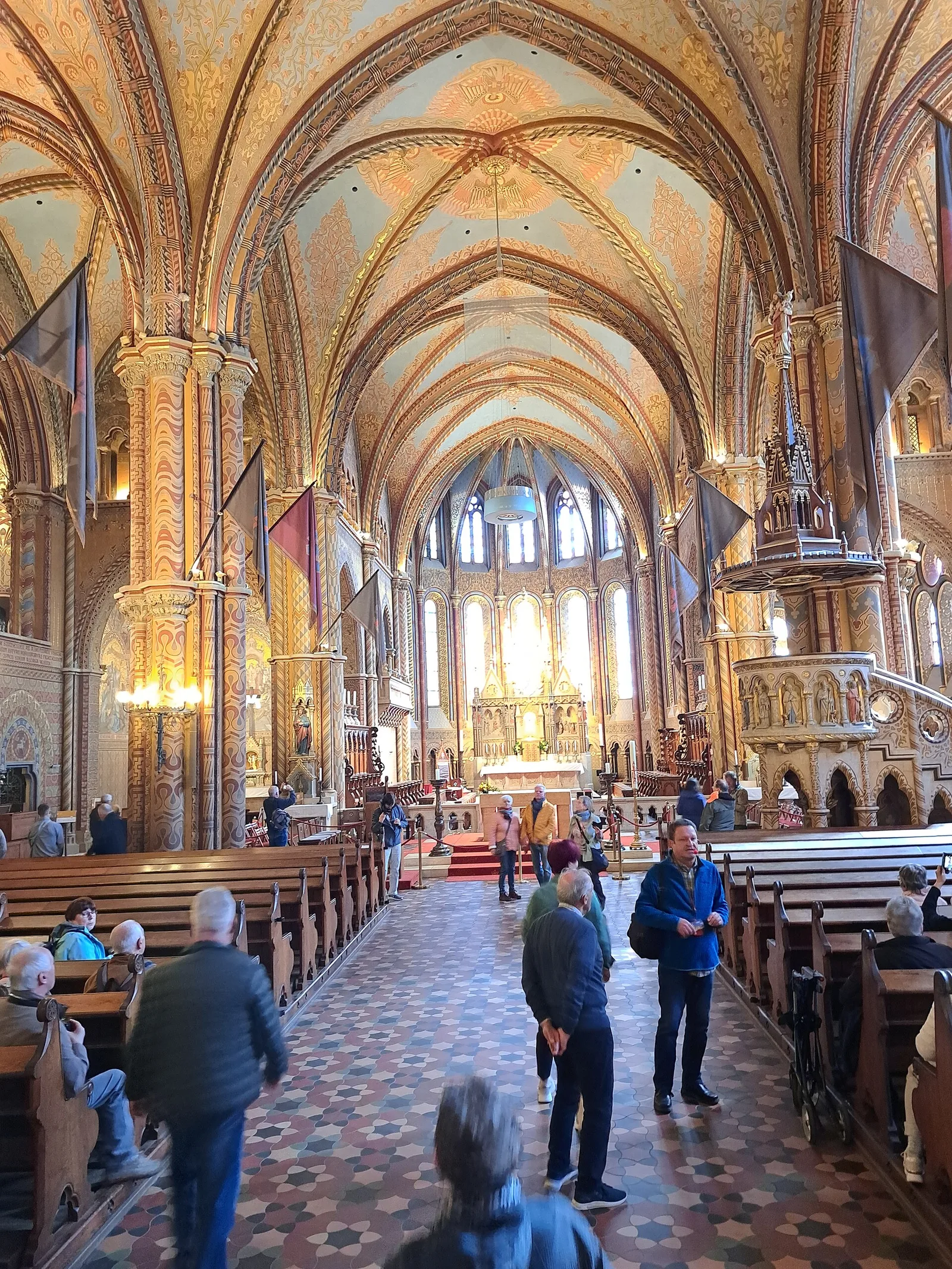The painted Gothic interior of the Matthias Church, with patterned pillars and vaulting