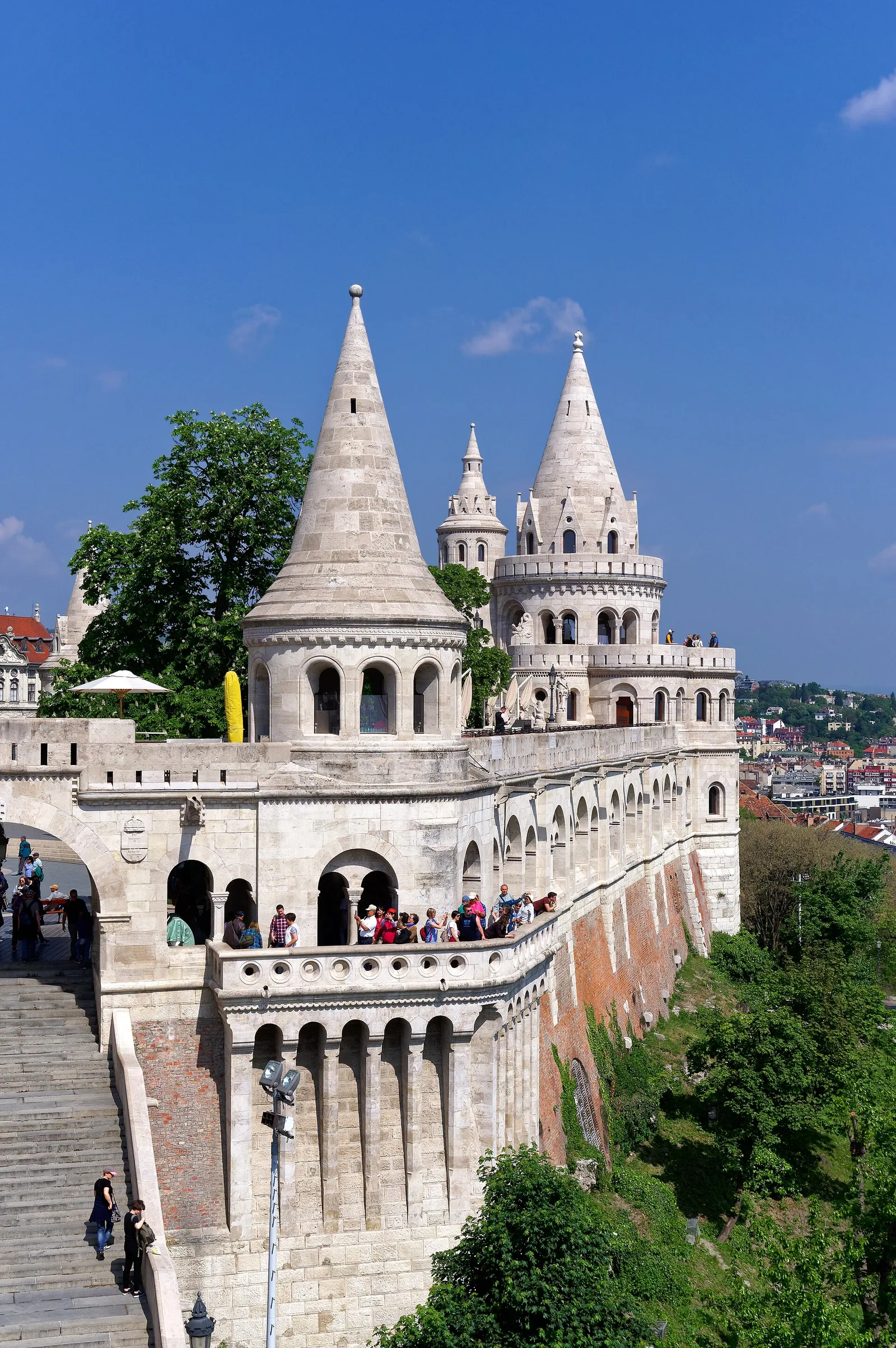 The white conical towers and arcaded terraces of the Fisherman’s Bastion with visitors on the terraces below