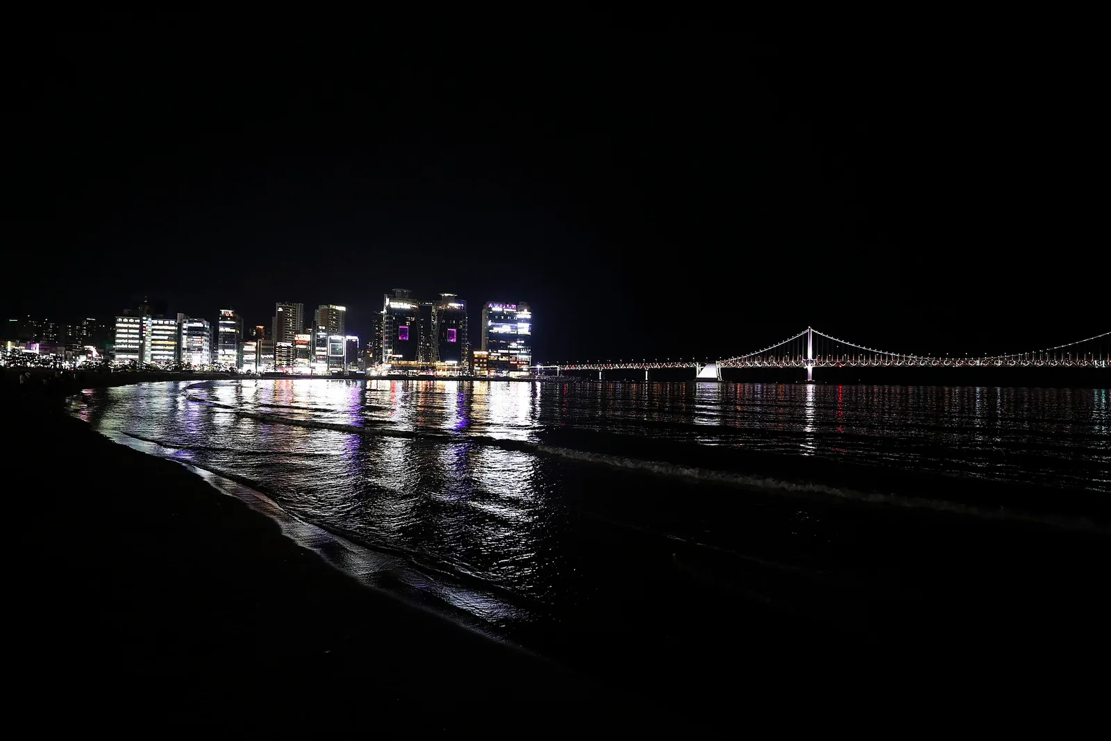 Gwangan Bridge lit up at night across the water from Gwangalli Beach