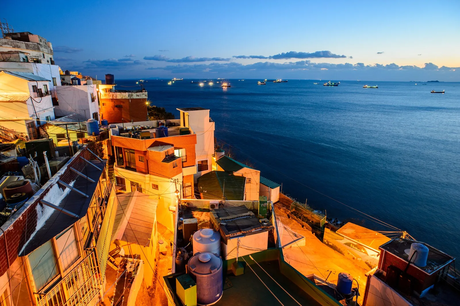 Rooftops on the Huinnyeoul Culture Village cliff above the sea at sunset