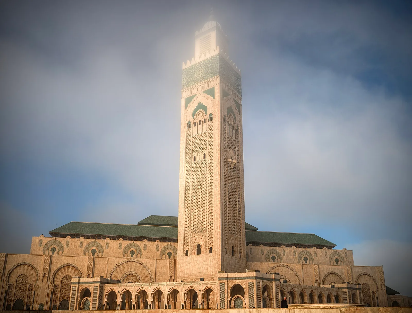 The tall, ornately tiled minaret of the Hassan II Mosque rising above its prayer hall