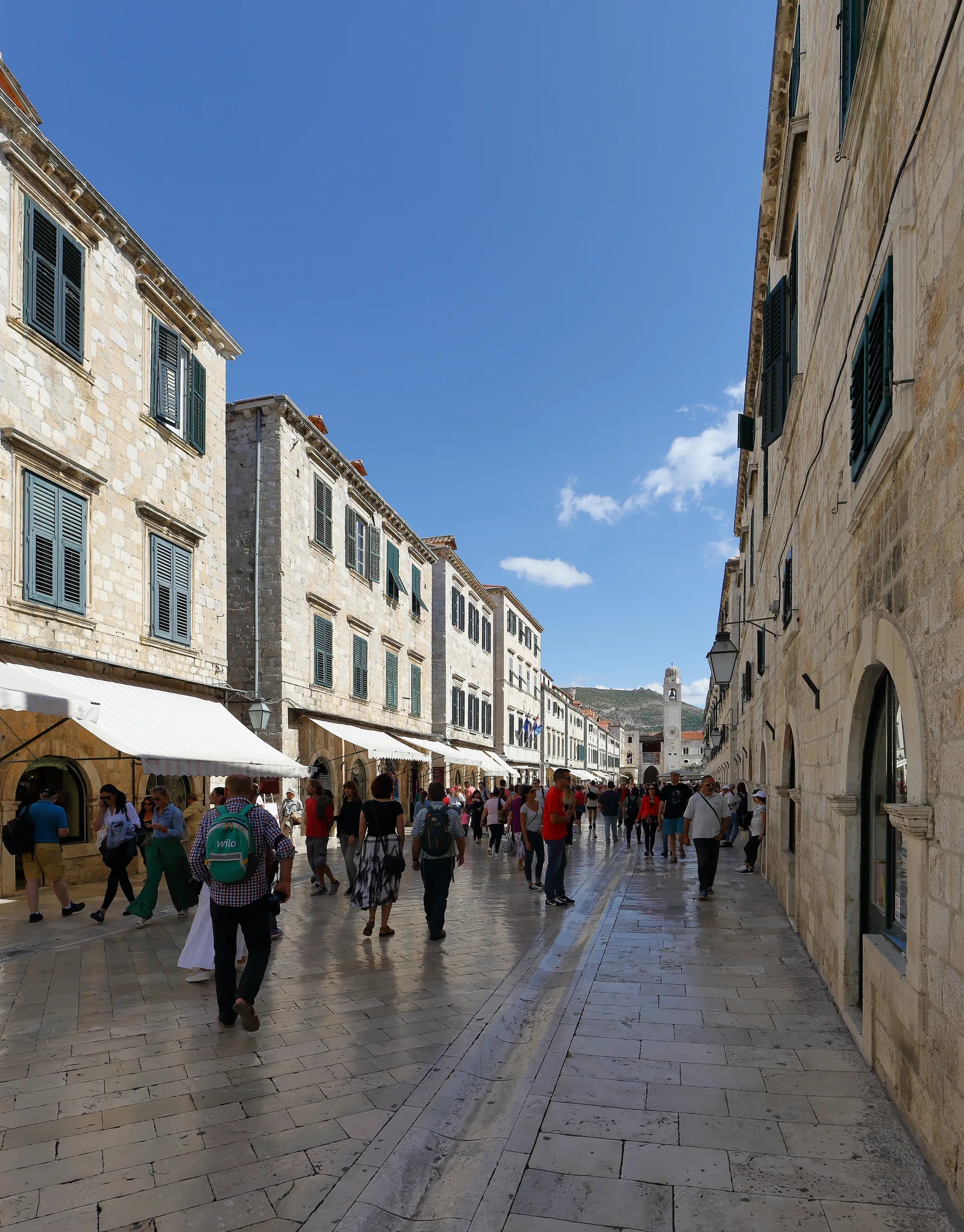 The limestone-paved Stradun lined with shuttered stone houses, with the bell tower at the far end