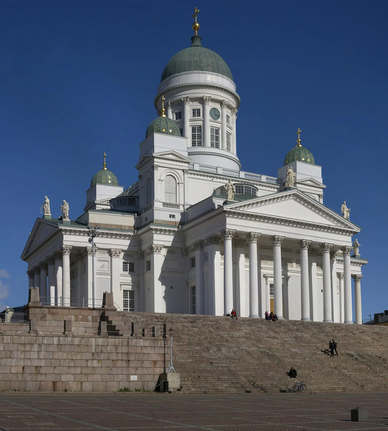The white neoclassical Helsinki Cathedral with its green domes, rising above a wide flight of granite steps