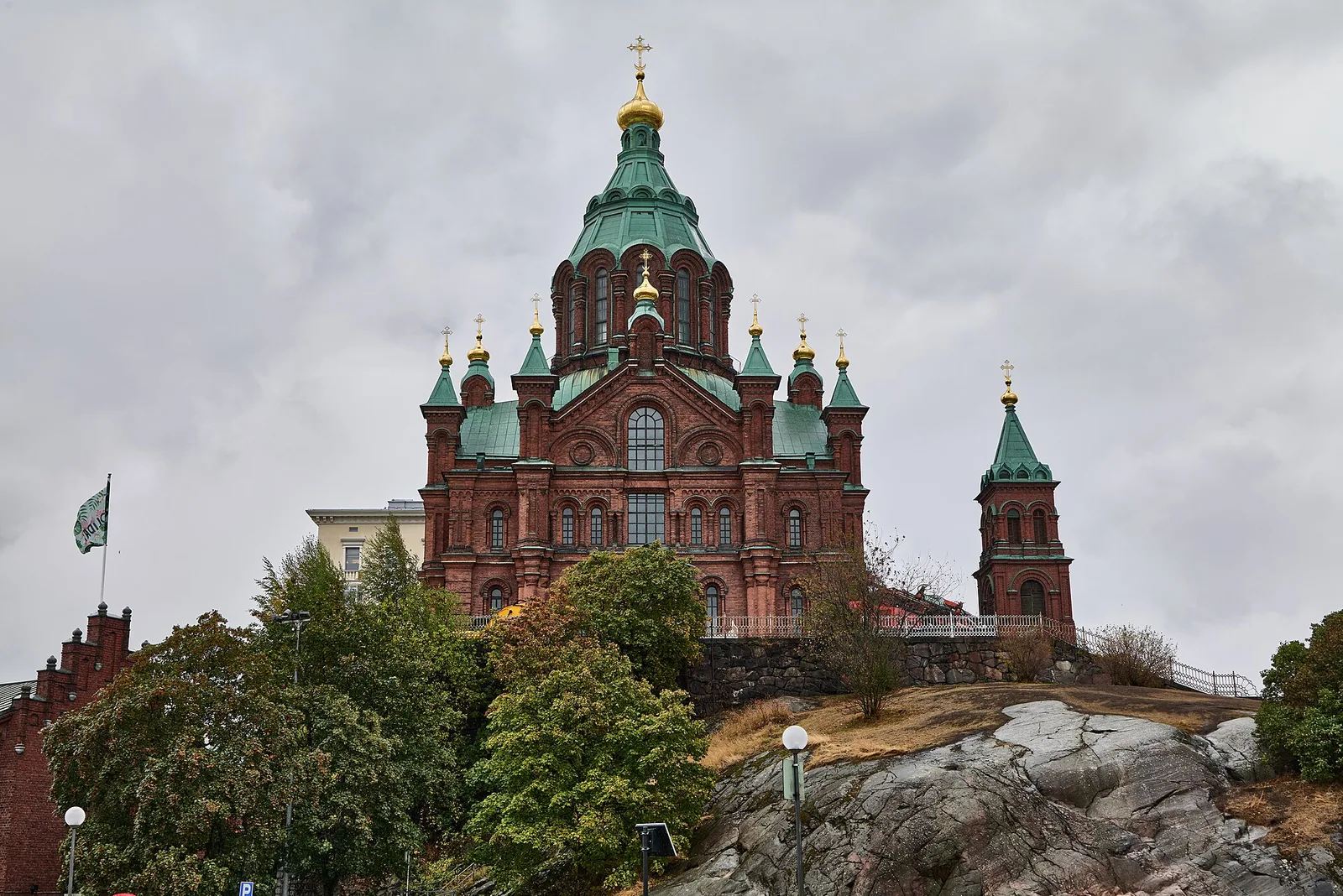 The red-brick Uspenski Cathedral with green roofs and gold domes on its rocky hilltop above the harbor