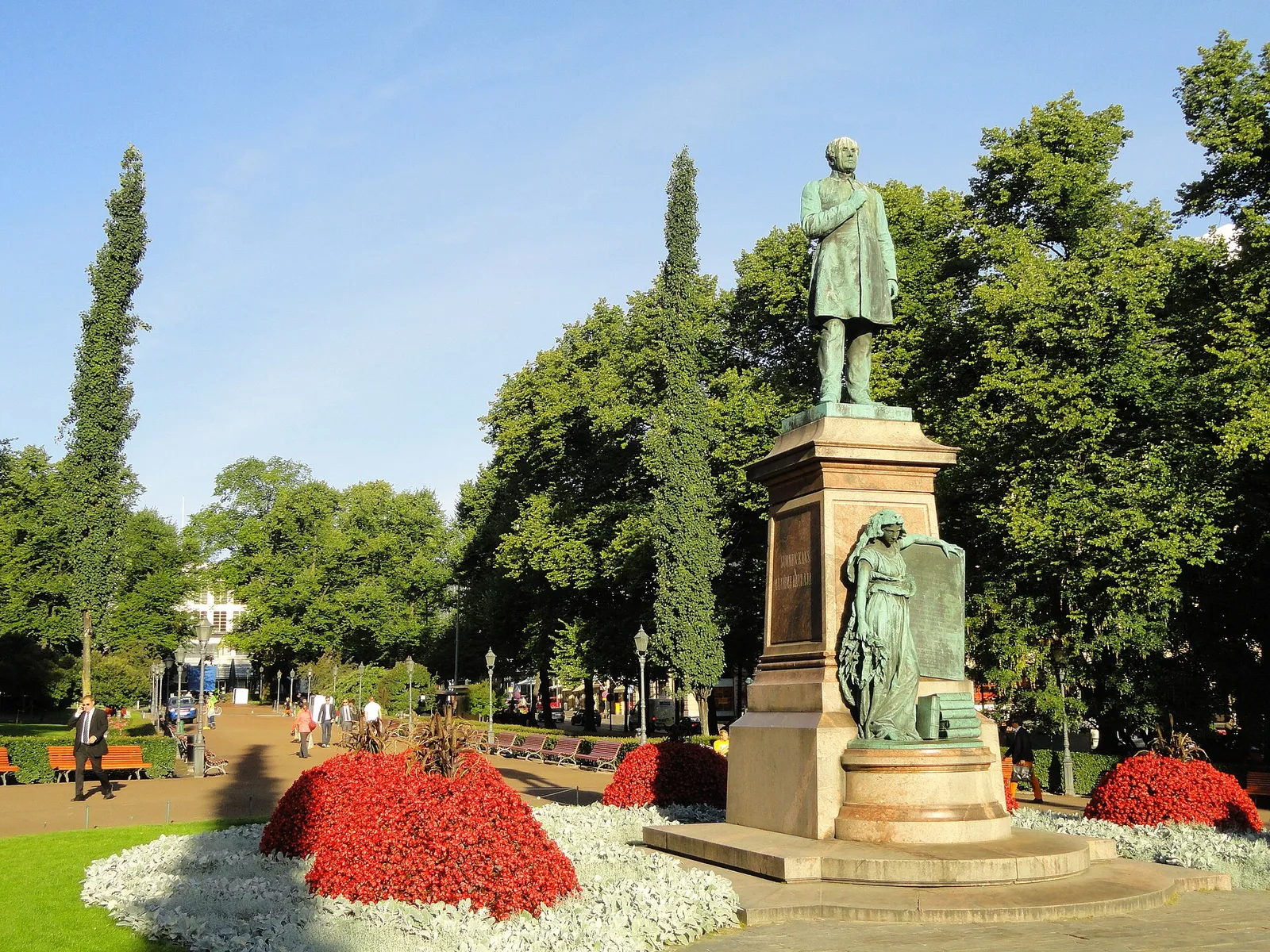 The bronze statue of poet Johan Ludvig Runeberg among flower beds and trees in Esplanadi park