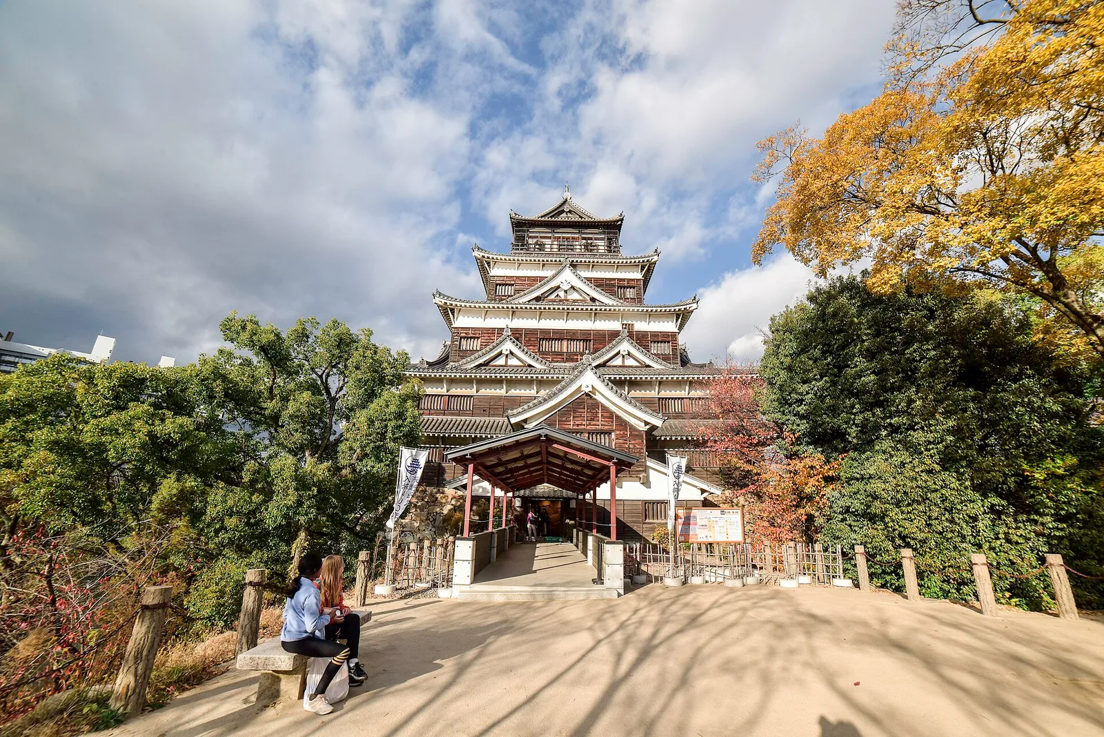 The rebuilt keep of Hiroshima Castle framed by autumn trees at the end of a gravel approach