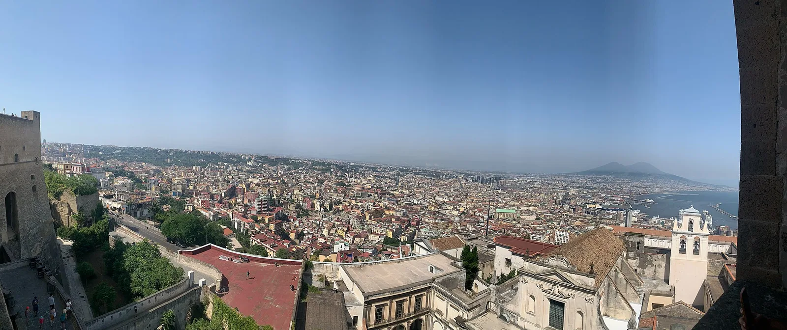 A panoramic view over the rooftops of Naples toward Mount Vesuvius and the bay, seen from Castel Sant’Elmo