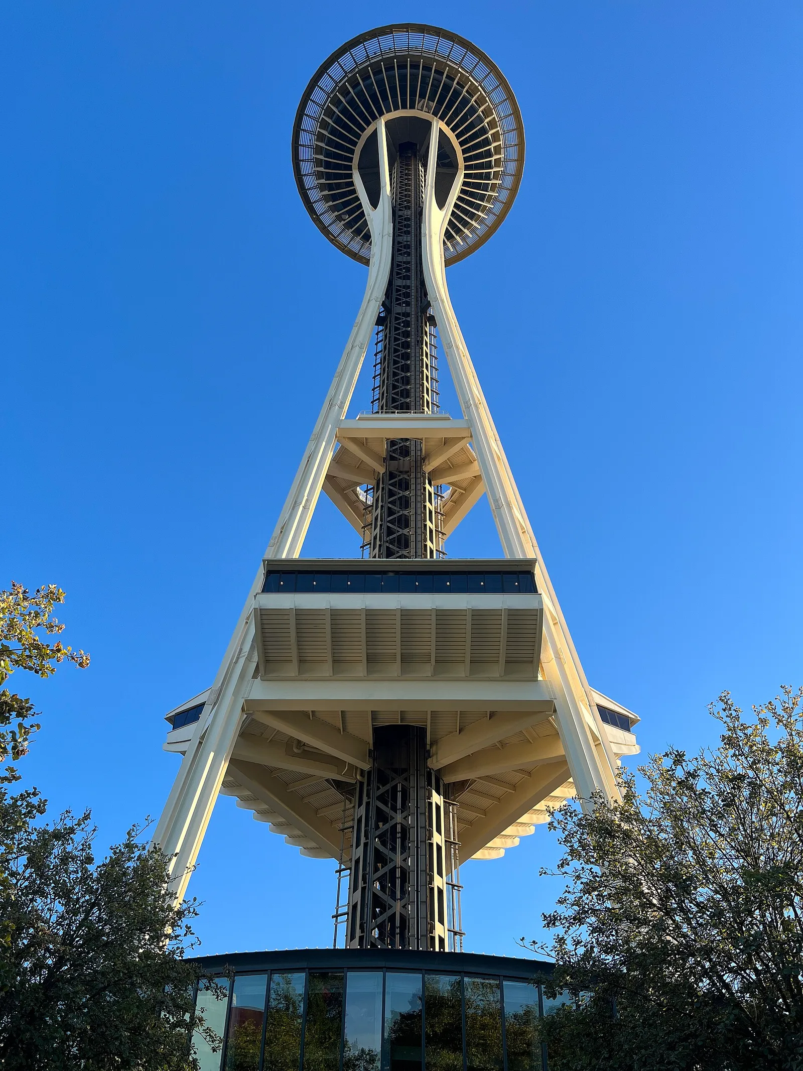 The Space Needle’s steel legs and saucer-shaped top seen from below against a clear blue sky
