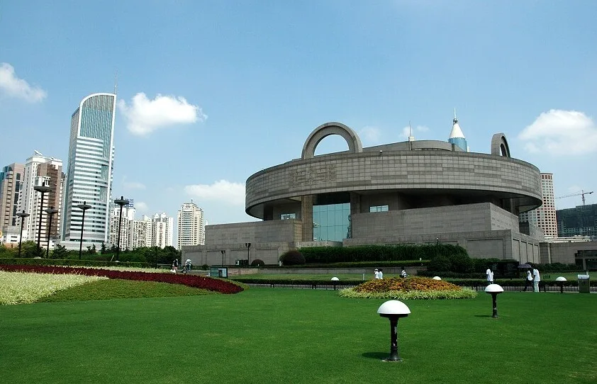 The round, bronze-ding-shaped Shanghai Museum building on its lawn at People’s Square