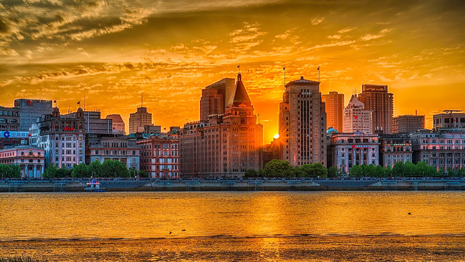The old Bund waterfront buildings glowing at sunset across the Huangpu River