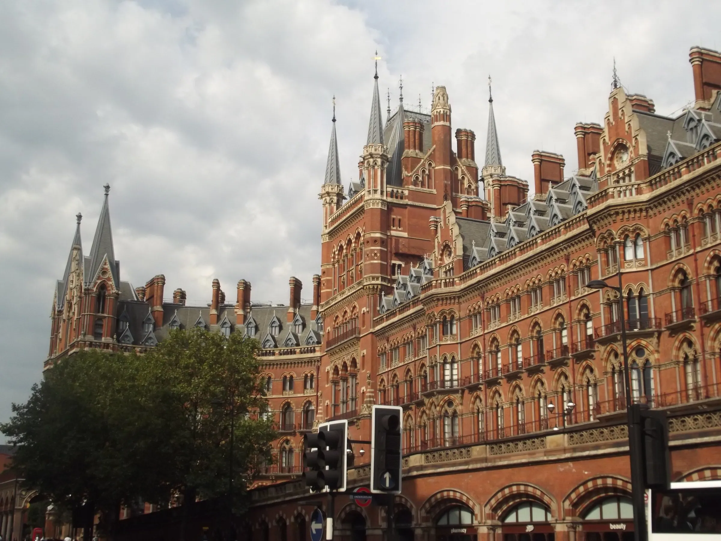 The red-brick Gothic Revival facade of St Pancras station in London, with its spires and clock tower under a cloudy sky
