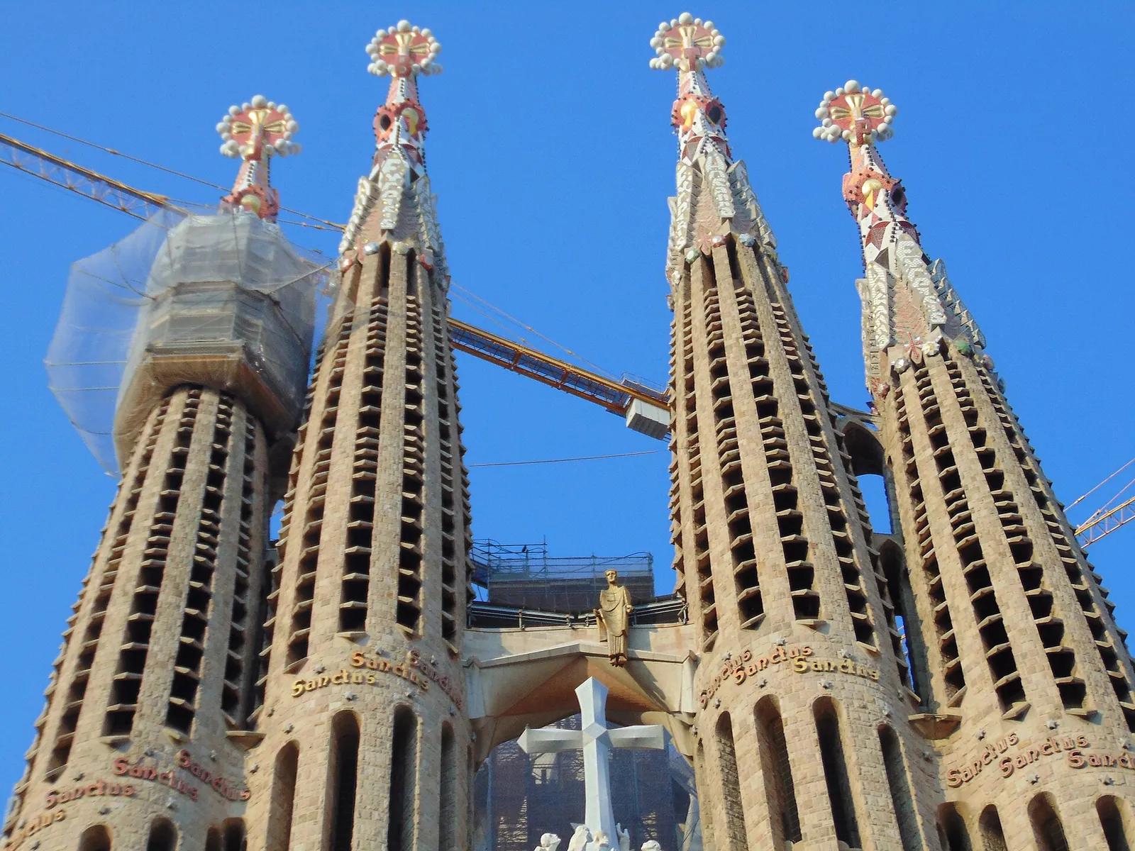 The tall stone spires of the Sagrada Família rising against a bright blue sky in Barcelona