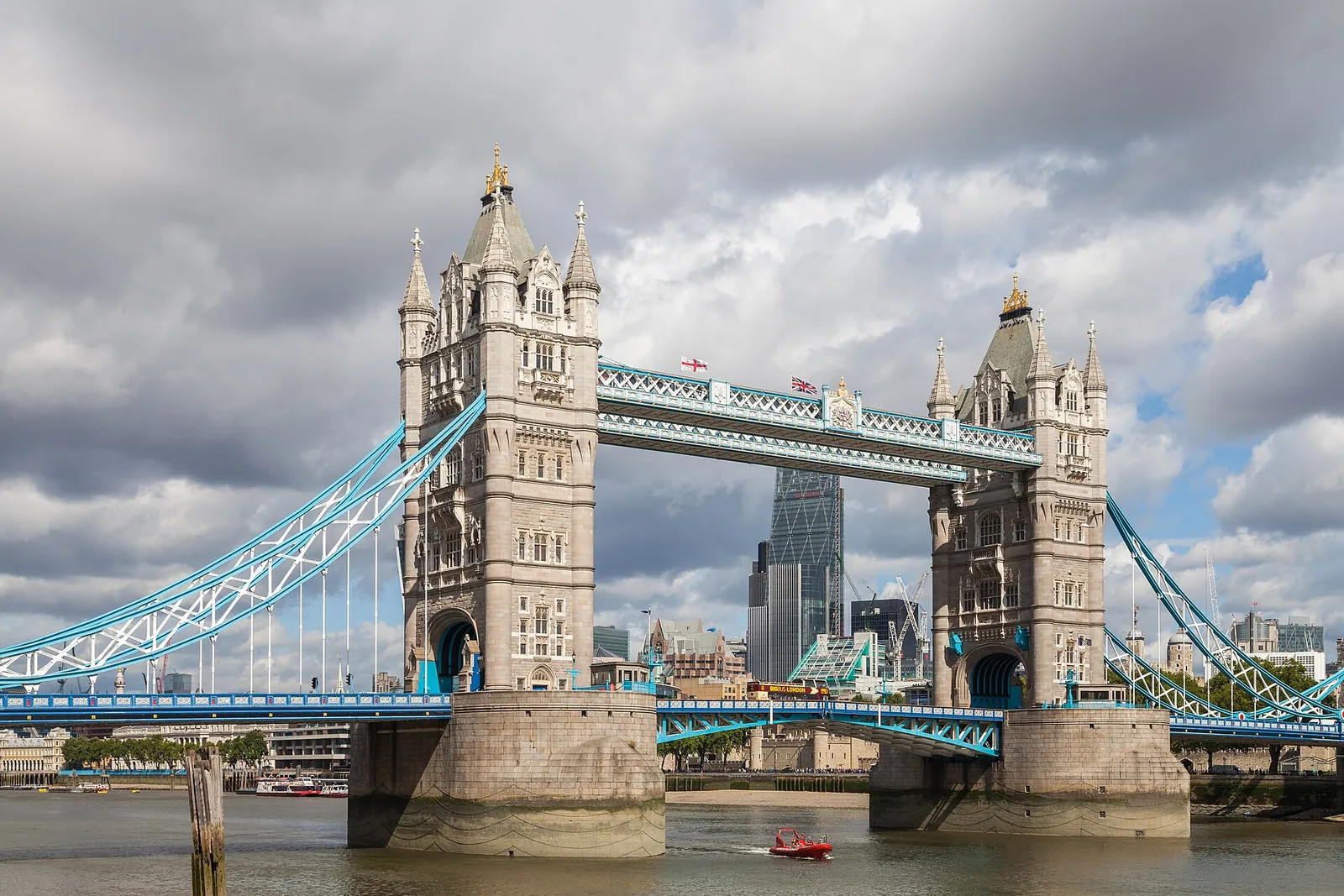 Tower Bridge crossing the Thames in London under a sky of broken clouds